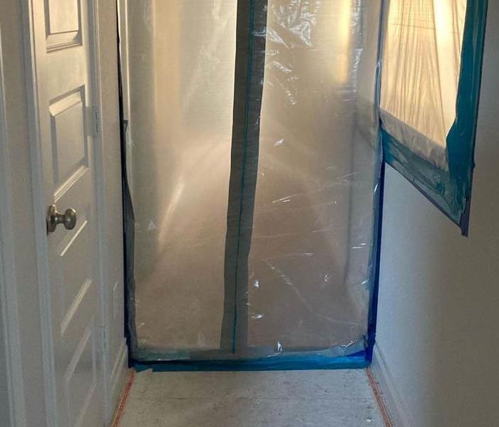 Plastic tarp and tape used as a containment system in a home.