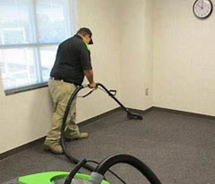 Man cleaning carpet in commercial building.