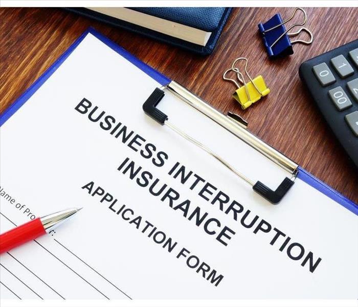 Business interruption insurance form and red pencil to sign.